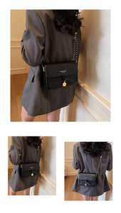 Detail view of black leather flap bag with star embossing and golden chain strap