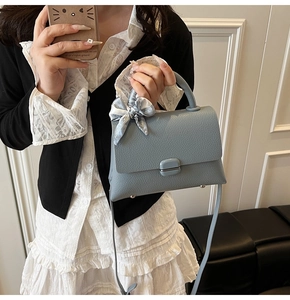 Light blue crossbody bag with lychee texture and silk scarf handle detail for women