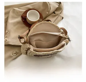 Detail view of woven straw round bag showing interior lining and zipper pocket