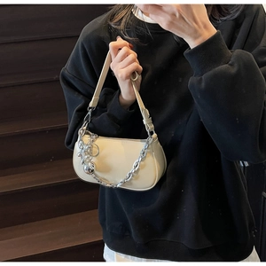 Détail du sac hobo avec chaîne argentée et breloque boule en métal poli élégant