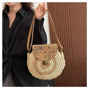 Detail of round straw crossbody bag with ethnic patterns and metal buckle closure