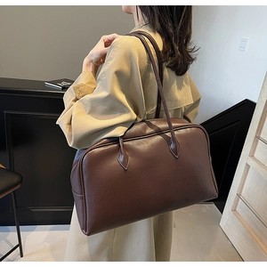 Detail of a large brown pebbled leather shoulder bag showing texture and spacious design