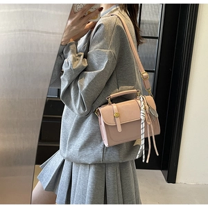 Pink rectangular crossbody bag with gold buckle and scarf detail shown in mirror selfie