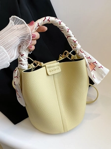 Chic cream yellow bucket bag with lychee texture and silk scarf wrapped handle