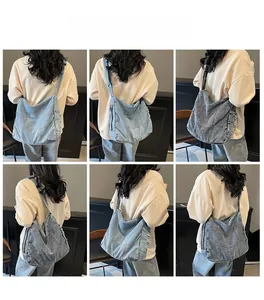 Detailed back view of a model wearing a large vintage washed denim crossbody bag