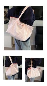 Detail of white canvas tote bag with red letter embroidery and red checkered lining