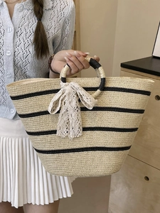 Artistic straw tote bag with black stripes and lace bow for summer beach vacation