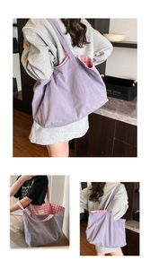 Detailed view of the double-sided canvas tote bag showing purple fabric and pink checkered lining