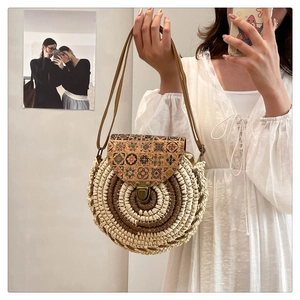 Close-up of bohemian round straw bag with ethnic print flap and vintage metal lock