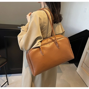 Close-up of a brown leather shoulder bag with lychee texture for office commuting