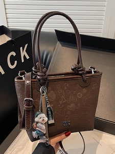 Dark brown embossed bucket bag with cute dog charm and leather crossbody strap