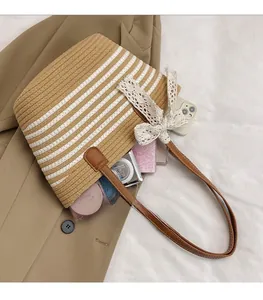 Detail view of woven straw tote bag with brown stripes and large interior capacity