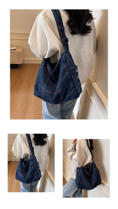 Detail of a large vintage-washed dark blue denim messenger bag with adjustable strap