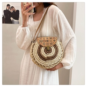 Close-up of circular woven crossbody bag with ethnic print flap and vintage bronze clasp