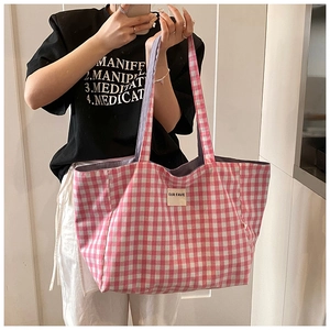 Detail of pink and white gingham tote bag with OUR FAVE label and wide shoulder straps