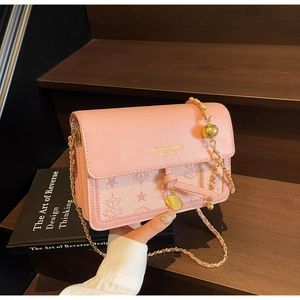 Detail of pink leather handbag showing gold MIKAXIQI branding and embossed star patterns