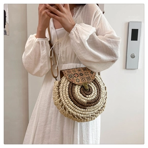 Detail showing the straw woven circular crossbody bag with colorful geometric patterns