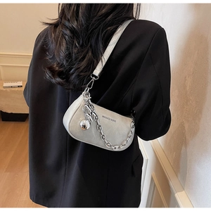 Détail du sac à bandoulière gris argenté avec chaîne en métal et pendentif sphère
