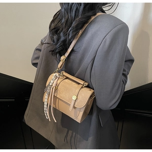 Chic tan square handbag with silk scarf detail shown in professional lifestyle setting