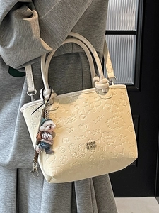 Elegant cream embossed bucket bag with cute cartoon motifs and adorable puppy charm