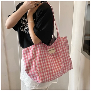 Detail of pink and white checkered tote bag with OUR FAVE label on casual canvas