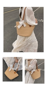 Close-up of woven straw tote bag featuring leather handles and white lace bow detail
