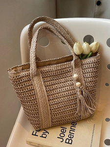 Woven straw tote bag with tassels and tulips, perfect for a casual summer vacation look