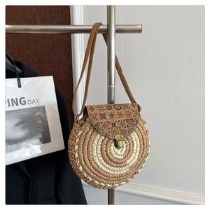 Detail of bohemian round straw bag with floral pattern cork lid and metallic brass lock