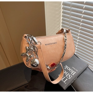 Détail du sac à bandoulière rose poudré en similicuir avec chaîne argentée et breloque chien