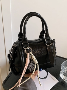 Minimalist black leather Boston bag with double handles and decorative tennis charms