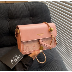 Pink embossed crossbody bag with golden chain strap and round pendant detail
