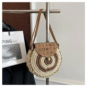 Detail of round straw bag with cork floral print flap and vintage bronze metal buckle