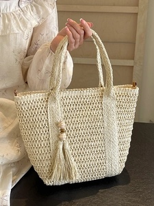 Minimalist woven straw tote bag in cream white with tassel charm for summer vacation