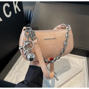 Détail du sac en daim rose pâle avec grosse chaîne argentée et breloque chien ballon