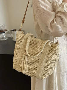 Minimalist beige woven tote bag with wooden bead tassel and long shoulder strap