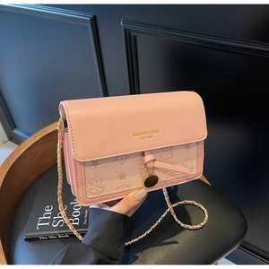 Detail of pink matte leather bag with gold chain strap and embossed star pattern
