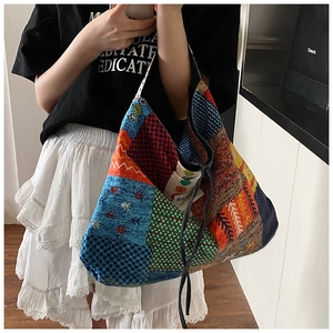 Detail of bohemian patchwork tote bag with colorful prints and drawstring closure on model