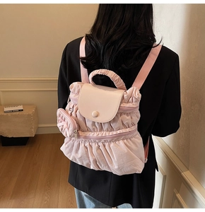 Close-up of pink pleated backpack with a matching mini pouch and flip cover detail