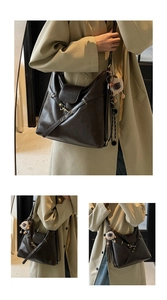 Detail of dark brown leather tote bag featuring metal buckle and cute sheep plush charm