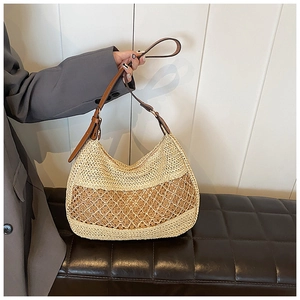 Detail of half-moon straw beach bag showing woven mesh texture and adjustable brown strap