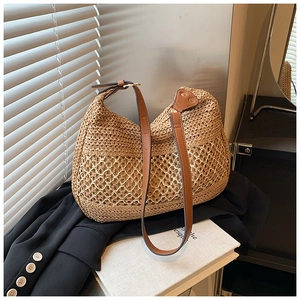 Close-up of woven straw tote bag featuring leather shoulder strap and mesh design