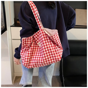 Close-up of red and white checkered canvas tote bag with a woven brand label