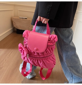 Pink pleated backpack with a matching heart-shaped coin purse and comfortable carry handle