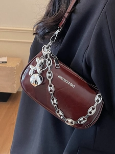 Sac sous le bras chic en cuir bordeaux avec chaîne argentée et breloque chien ballon