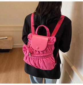Detailed back view of a pink pleated backpack with a matching heart-shaped coin purse