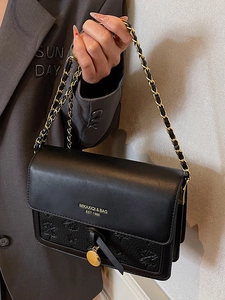 Fashionable black embossed crossbody bag with gold chain strap and vintage branding