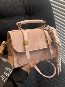 Pink minimalist crossbody bag with top handle and gold circular metal hardware detail