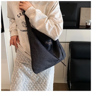 Deep grey denim hobo tote bag featuring light embroidery and wide shoulder strap