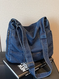 Minimalist navy denim messenger bag with adjustable wide strap and multi-pocket design