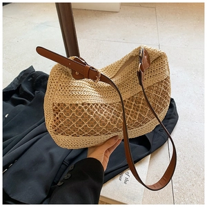 Close-up of woven straw tote bag featuring intricate hollow wave patterns and leather strap